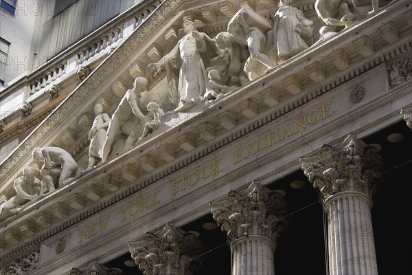 USA, New York, New York City, Manhattan  The New York Stock Exchange building in Broad Street beside Wall Street showing the main facade of the building featuring marble sculpture by John Quincy Adams Ward in the pediment called Integrity Protecting the W