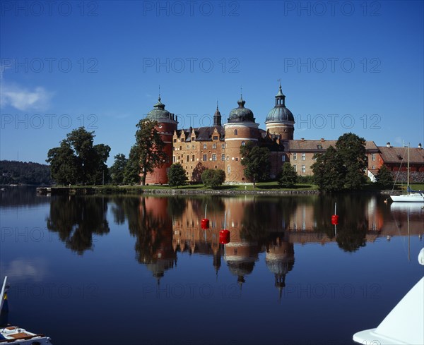 Sweden, Sodermanland, Mariefred, Gripsholm Castle beside Lake Malaren.  Red brick exterior with domed towers  dating from the sixteenth century  reflected in water.