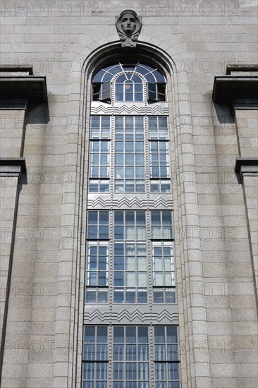 Ireland, County Dublin, Dublin City, Department of Industry and Commerce Government building in Kildare Street showing a head popping out of the top of the building representing Eire Art Deco with some Celtic themes.