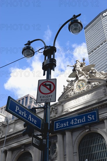 USA, New York, New York City, Manhattan  Sculpture by Jules-Alexis Coutans of Mercury  Hercules and Minerva on the 42nd Street facade of Grand Central Terminal railway station and a streetlight with road signs for Park Avenue and 42nd Street.