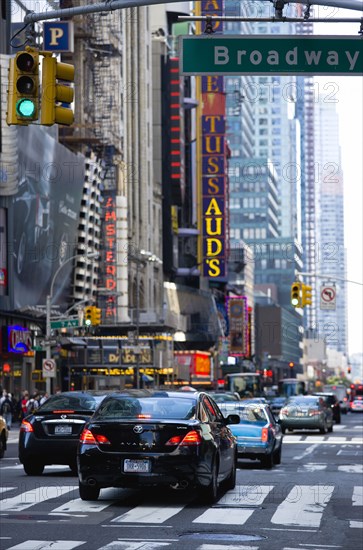 USA, New York, New York City, Manhattan  Cars crossing Broadway at green traffic lights travelling east along 42nd Street past the New Amsterdam Theater and Madame Tussauds.