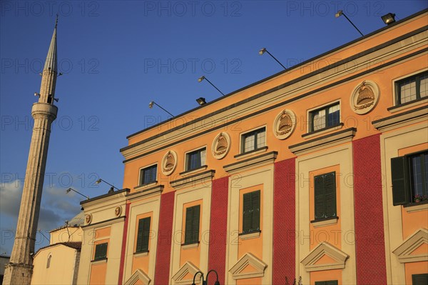 Albania, Tirane, Tirana, Pink and yellow government building facades beside minaret of Ethem Bey Mosque in Skanderbeg Sqaure.