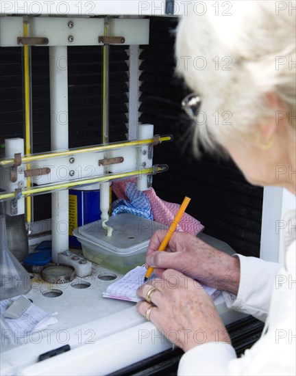 Climate, Weather, Measurements, Female weather observer recording readings from the two thermometers which measure minumum and maximum tempertures in the Stevensons Screen cabinet at Bognor Regis weather station.