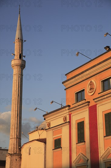 Albania, Tirane, Tirana, Pink and yellow government building facades beside minaret of Ethem Bey Mosque in Skanderbeg Sqaure.