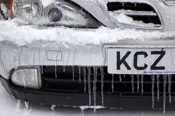 Weather, Winter, Ice, Melting snow and icicles on car fender and grill.