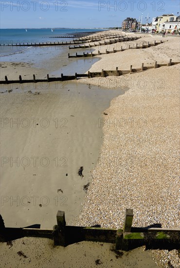 England, West Sussex, Bognor Regis, Wooden groynes at low tide used as sea defences against erosion of the shingle pebble beach.