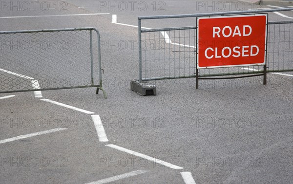 Transport, Road, Signs, Red Road Closed Traffic sign on barrier across empty urban road.