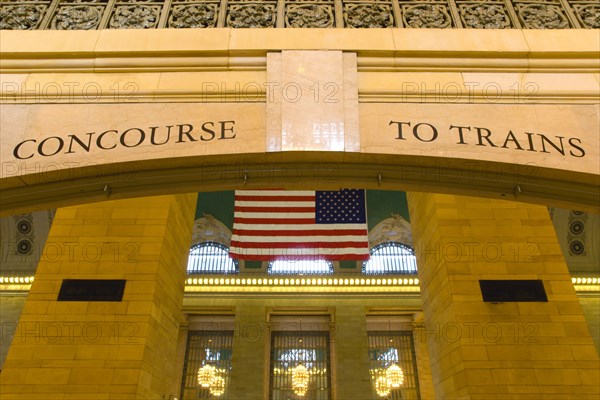 USA, New York, New York City, Manhattan  Grand Central Terminal railway station entrance to the Main Concourse from the Vanderbilt Hall with the American Stars and Stripes flag hanging from the ceiling.