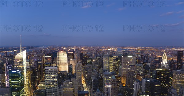 USA, New York, New York City, Manhattan  View from Empire State building over midtown skyscrapers with Art Deco Chrysler Building illuminated at sunset.