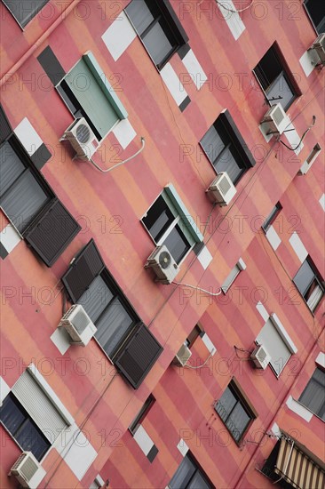 Albania, Tirane, Tirana, Angled part view of exterior facade of colourful apartment building with shuttered windows and air conditioning units.