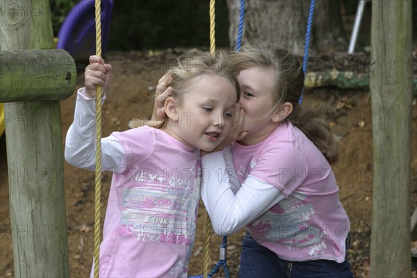 Children, Girls, Sisters whispering to each other.