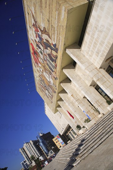 Albania, Tirane, Tirana, National History Museum. Angled view of exterior facade and entrance to the National History Museum in Skanderbeg Square with mosaic representing the development of Albanias history. City buildings beyond.