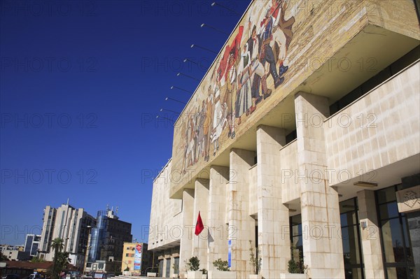 Albania, Tirane, Tirana, National History Museum. Exterior facade and entrance of the National History Museum in Skanderbeg Square with mosaic representing the development of Albanias history. City buildings beyond.