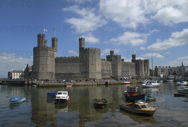 Wales, Gwynedd, Conway, Conway Castle seen over moored boats in the harbour