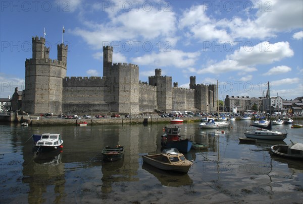 Wales, Gwynedd, Conway, Conway Castle seen over moored boats in the harbour