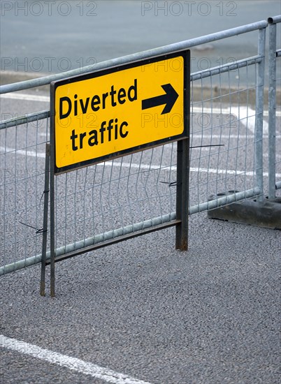 Transport, Road, Signs, Yellow Diverted Traffic diversion sign on barrier across empty urban road in Bognor Regis.