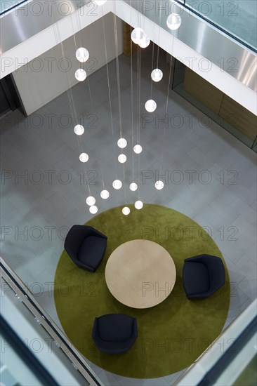 Ireland, County Dublin, Dublin City, Ballsbridge  Lansdowne Road  Aviva Stadium interior stairwell with table and chairs on carpet beneath chandelier in the Presidents suite area.