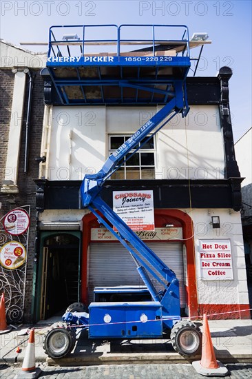 Ireland, County Dublin, Dublin City, Raised hydraulic cherry picker platform used by decorators beside a building in Temple Bar.