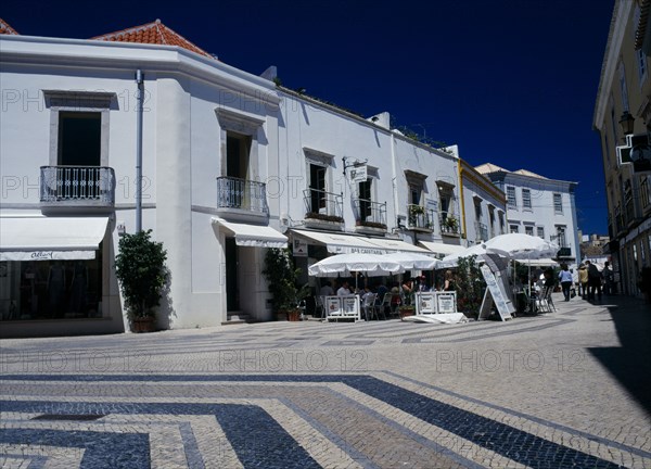 Portugal, Algarve, Faro, Main shopping area with white washed buildings and colourfully decorated pavement