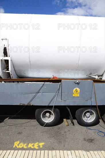 England, West Sussex, Bognor Regis, Funfair ride the Rocket parked on trailer on the Esplanade with the word Rocket written in yellow spray paint on the road beside it. Danger Of Elecrocution hazard warning sign on trailer.