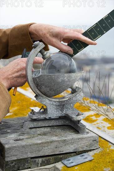 Climate, Weather, Measurements, CampbellStokes sunshine recorder or Stokes sphere on the top of the tallest building in Bognor Regis used by weather observers to monitor the hours of sunshine with observer inserting a summer card.