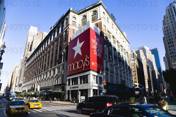 USA, New York, New York City, Manhattan  Macys department store with cars on 34th Street and people walking in the pedestrianised Broadway.