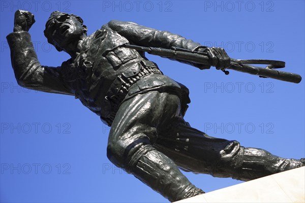 Albania, Tirane, Tirana, Statue of the Unknown Partisan  from low angle looking upwards  against blue sky.