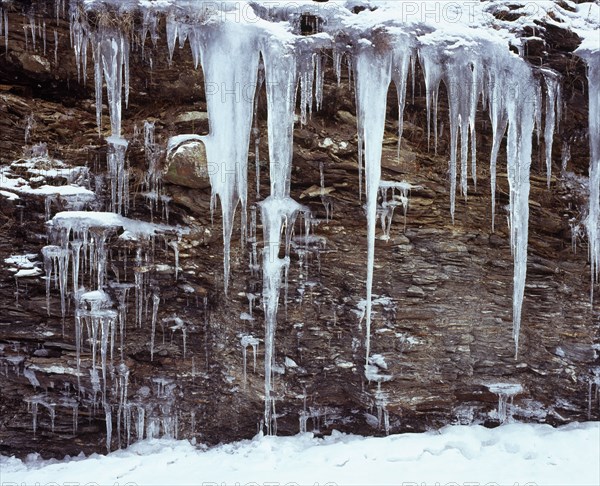Climate, Winter, Ice, Long icicles hanging from rock face.