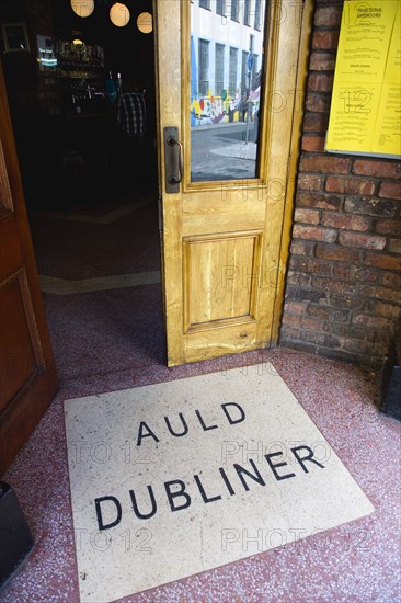 Ireland, County Dublin, Dublin City, Entrance door to the Auld Dubliner pub in Temple Bar with the name written on the ground.