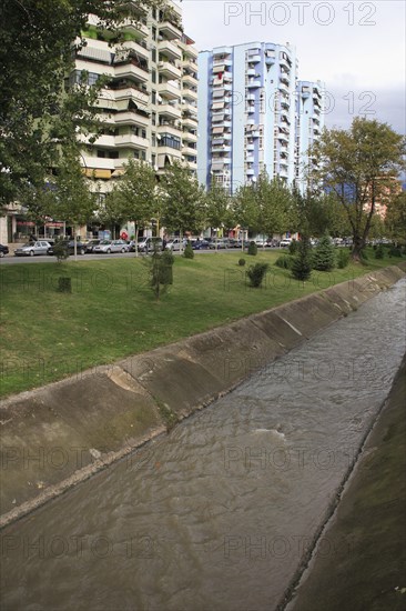 Albania, Tirane, Tirana, River Lana running past apartment blocks.