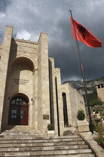 Albania, Kruja, Kruja Castle and Skanderbeg Museum  exterior facade with steps to entrance and National flag raised on flagpole at side.
