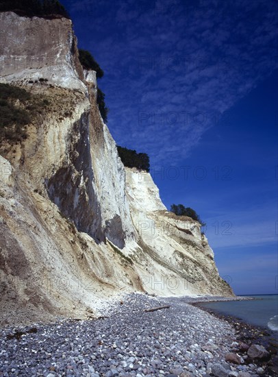 Denmark, Isle of Mon, Mons Klint, East facing chalk sea cliffs with flintstone beach.  Blue sky with high windswept clouds above.