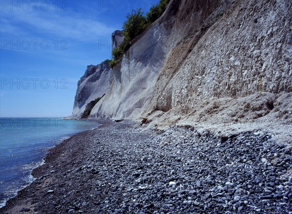 Denmark, Isle of Mon, Mons Klint, East facing chalk sea cliffs with flintstone beach. Blue sky with high windswept clouds above.