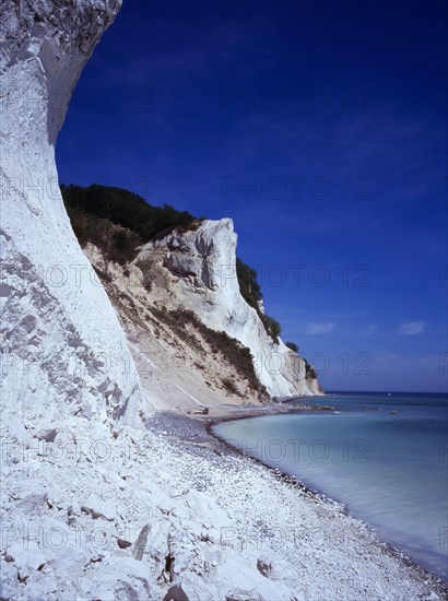 Denmark, Isle of Mon, Mons Klint, East facing chalk sea cliffs with flintstone beach.  Blue sky with high windswept clouds above.