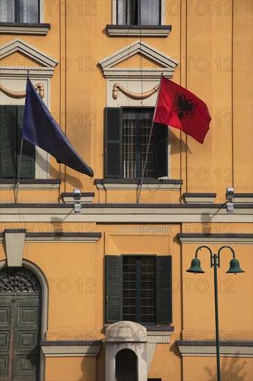 Albania, Tirane, Tirana, Detail of exterior facade of government buildings in Skanderbeg Square displaying flags including double headed eagle.