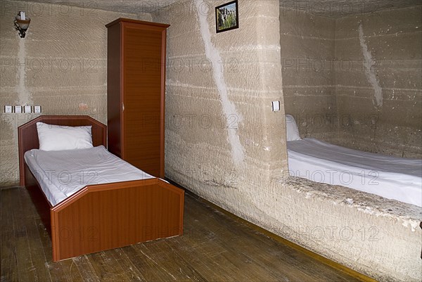 Room with bed in typical cave hotel carved from volcanic tufa rock. Photo: Hugh Rooney