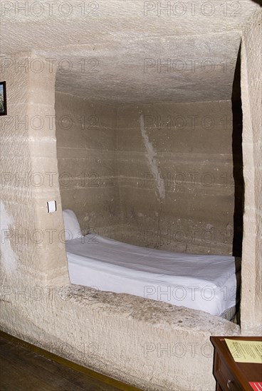 Room with bed in typical cave hotel carved out of volcanic tufa rock. Photo: Hugh Rooney