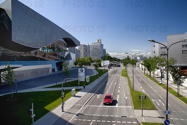 BMW Welt showroom on left hand side opposite the head-quarters building with car on multi-lane road in foreground. Photo : Hugh Rooney