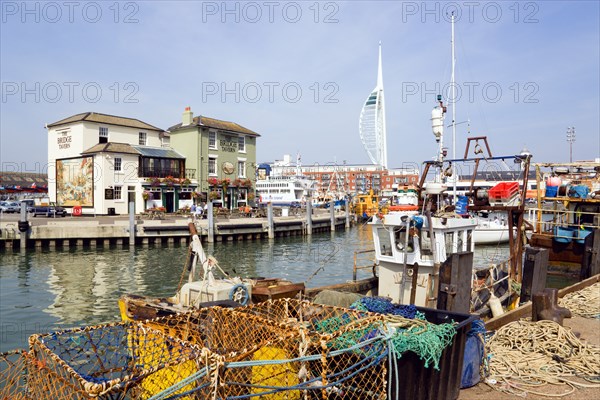 The Camber in Old Portsmouth showing the Spinnaker Tower behind the Bridge Tavern with its mural of Thomas Rowlansons cartoon titled Portsmouth Point and fishing boats moored along the quayside. Photo : Paul Seheult