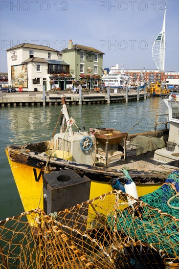 The Camber in Old Portsmouth showing the Spinnaker Tower behind the Bridge Tavern with its mural of Thomas Rowlansons cartoon titled Portsmouth Point and fishing boats moored along the quayside. Photo : Paul Seheult