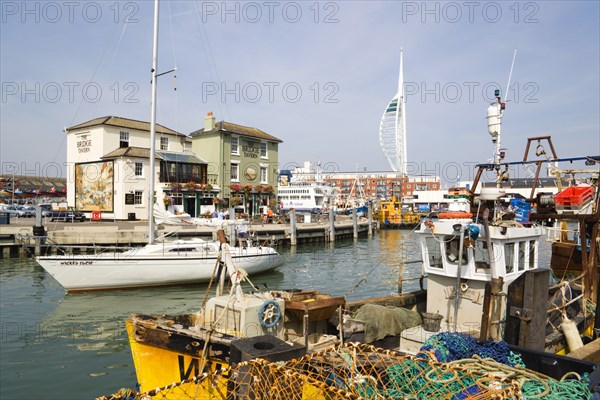 The Camber in Old Portsmouth showing the Spinnaker Tower behind the Bridge Tavern with its mural of Thomas Rowlansons cartoon titled Portsmouth Point and fishing boats moored along the quayside. Photo : Paul Seheult