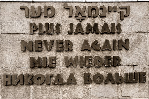 Dachau World War II Nazi Concentration Camp. Sign written in Hebrew French English German and Russian that reads Never Again. Photo : Hugh Rooney