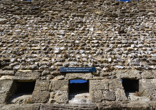 Portchester Castle Norman 12th Century flint walls with the garderobe chutes or toilets from the old Augustine priory. Photo : Paul Seheult