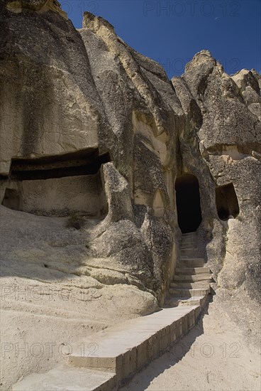 Open Air Museum. Detail of one of nine churches carved out of a ring-shaped rock formation with narrow flight of steps leading to entrance. Photo : Hugh Rooney