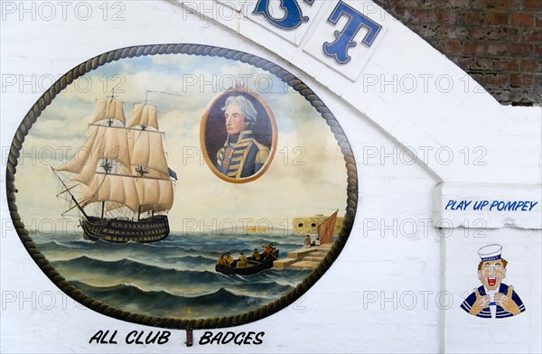 Wall paintings outside tattooist parlour underneath arches at Portsmouth Harbour railway station showing sailor with local football club slogan Play Up Pompey and an old painting of Admiral Lord Nelson and the harbour. Photo: Paul Seheult