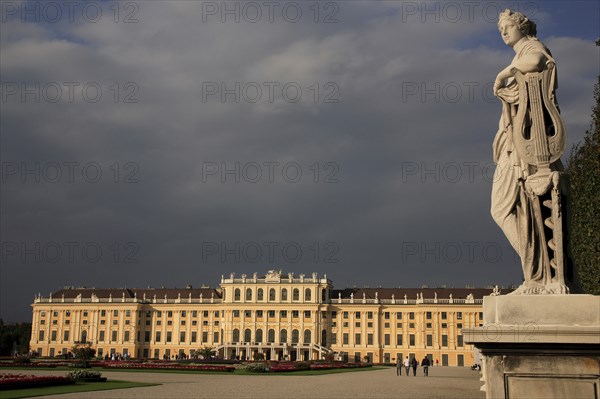 Schonnbrunn Palace. Exterior with statue of standing figure in foreground beneath grey stormy sky. Photo: Bennett Dean