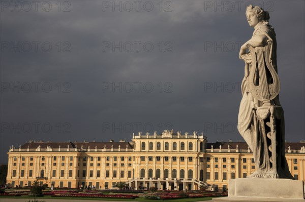 Schonnbrunn Palace. Exterior with statue of standing figure in foreground beneath grey stormy sky. Photo : Bennett Dean
