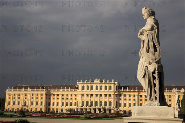 Schonnbrunn Palace. Exterior with statue of standing figure in foreground beneath grey stormy sky. Photo : Bennett Dean