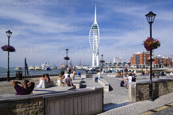The 170 metre tall Spinnaker Tower and Historic naval Dockyard seen from Bath Square on Spice Island in Old Portsmouth with people seated in the foreground. Photo : Paul Seheult