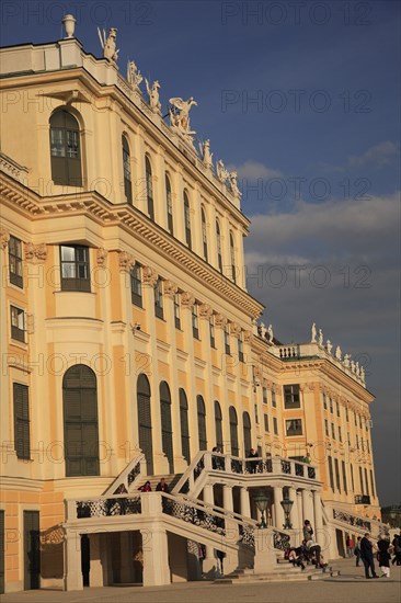 Schonnbrunn Palace. Part view of exterior facade with tourist visitors in courtyard and on steps and balcony.. Photo: Bennett Dean